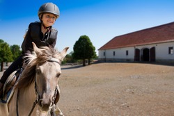 Horseback riding, lovely equestrian - little girl is riding a horse
