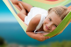 Summer vacation - lovely girl in colorful hammock