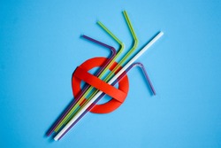 No use symbol in red with plastic straws and fork on blue background.  Plastic pollution is harmful to  marine lives including turtle, shark and whale. Environmental concept. Ban single use plastic.
