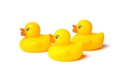 Three toy yellow rubber ducks for swimming, isolated on a white background. Side view