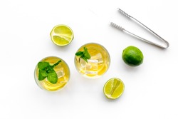 Alcoholic beverage. Whiskey with ice, mint and lime on white background top view