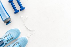 Crossfit equipment. Dumbbells and sneakers on white background top-down copy space