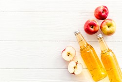 Apple cider vinegar bottle on white wooden background top view copy space