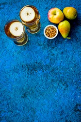 Fruit drinks with apple and pear on blue background from above copy space