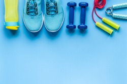 Athlete set of sneakers and bottle of water on bright blue background
