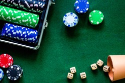 Poker set in a metallic case on a green gaming table top view copyspace