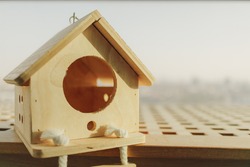 Little wooden house for small pet in warm light in concept of buying dream house.