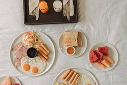 Hotel complimentary breakfast sets served on white bed.