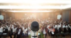 Microphone over the Abstract blurred photo of conference hall or seminar room with attendee background,Small Business training concept,Public speaking