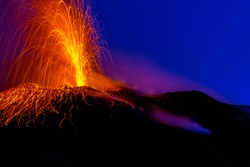 active volcano spraying lava into the night on Stromboli island in Italy