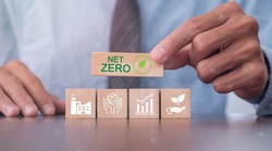 Hand puts wooden cubes with net zero icon in Net zero on grey background. Net zero by 2050. Carbon neutral. Net zero greenhouse gas emissions target. Climate neutral long term strategy.