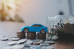 Saving money for a car or material design concepts. Miniature car model and Financial statement with coins. Finance and banking concept