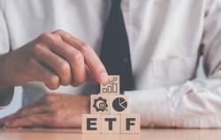 Investor holds the wooden cube with bitcoin icon standing with ETF text. Entering the digital money fund. ETF Exchange Traded Fund, business finance conceptual.