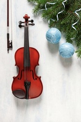 Old violin and fir-tree branches with Christmas decor. Christmas, New Year's concept. Top view, close-up.	