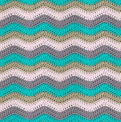 Seamless knitted pattern in the form of zigzags is crocheted with multi-colored threads. Acrylic baby yarn. Pastel shades.