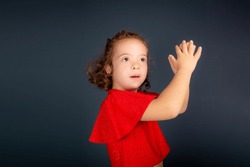 Beautiful and happy girl making hand gestures. Isolated on gray background.