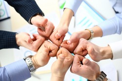 Close-up of smart people performing cooperation gesture to greet presumptive boss or colleagues and show increased level of cohesion and solidarity. Company meeting concept