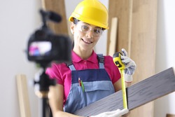 Woman master writes down tips for laying laminate apartments on camera. Selling floor coverings online concept