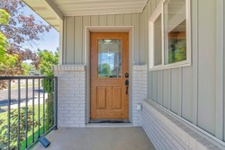 Front wooden door exterior with ornate glass panel and digital entry access with keypad