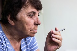 Senior woman smoking a cigarette 