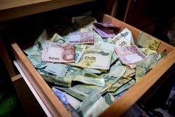 Many banknotes are inside the drawer.