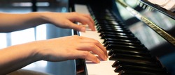 banner close up picture of hand of young pianist playing piano at home