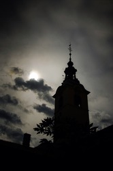 the mystical silhouette of an church bell tower with the dark sky in the background, vertical wallpaper, spooky atmosphere 