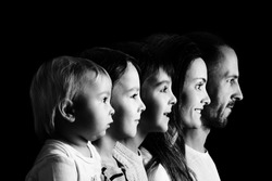 Family portrait of father, mother and three boys, profile picture of them all in a row, isolated on black background, monochrome version