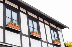 Facade of old bavarian building. Historical architecture. Middle ages apartment in Nuremberg. Half-timbered house with flower pot. Exterior of ancient house. Travel in Germany.