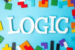LOGIC text with colorful wood puzzle pieces, geometric shape block on blue background. Concepts of logical thinking, Conundrum, solutions, rational, strategy, world logic day and Education