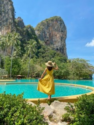 Woman tourist in yellow dress and hat traveling on Railay beach, Krabi, Thailand. vacation, travel, summer, Wanderlust and holiday concept