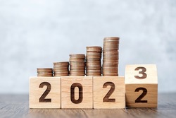flipping 2022 to 2023 year block with Coins stack. Money, Budget, tax, investment, financial, savings and New Year Resolution concepts