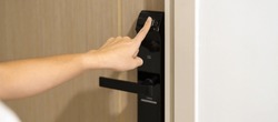 Hand using fingerprint scan for smart digital door lock while open or close the door at home or apartment. NFC Technology, keycard, PIN number, smartphone and contactless lifestyle concepts