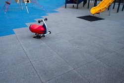 rocker toy rider in a children's public playground with rubber tiled mats