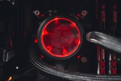 Inside a high performance computer. Computer circuit board and CPU cooling fans illuminated by internal LED