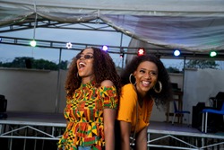 two black girls dancing at a concert held at night