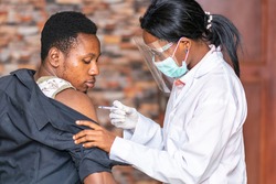 medical personnel administers a vaccine to a patient