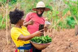 two african farmers excited after checking a phone