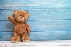 Cute teddy bear with copy space on blue color wood background.