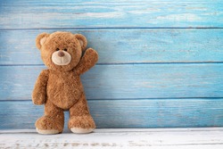 Cute teddy bear with copy space on blue color wood background.