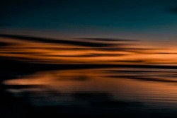 Intentional camera movement in a beach sunset. Horizontal sweep effect. Abstract landscape. Long exposure photography.