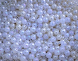 Several pearlescent and white pearls with holes to form necklaces. Plastic pearls in the market.