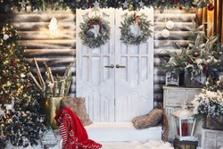 Winter rustic interior decorated for New year with artificial snow and Christmas tree. Winter exterior of a country house with Christmas decorations in rustic style. Christmas eve
