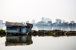 Barrack at lake in Hanoi against skyline of skyscrapers