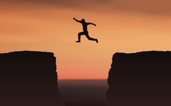 Silhouette Man jumping over gap between cliff with evening sunset sky background
