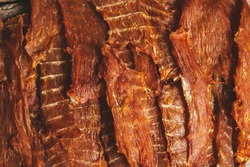 delicious jerky on a wooden background. products in craft packaging. snack for alcohol. macro photo. close-up