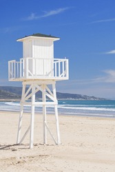 White lifeguard tower on a deserted beach on a clear sunny day