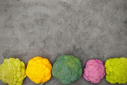 Different varieties of cabbage and cauliflower on gray background