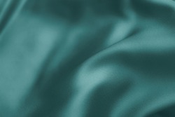 Soft silk cloth or satin texture.  Wrinkled fabric backdrop. 2021 Color Trends Tidewater Green