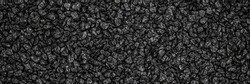 Noisy Black basalt background. Banner. black sand texture. Lots of lava small stones. Dark quartz aquarium substrate. Garden pond gravel backdrop. Terrarium natural  fine-grained igneous rock